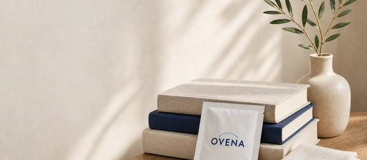 An Ovena sachet and folded gauze pad on stacked books
