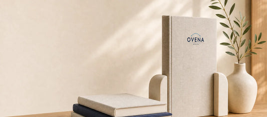 Ovena Health logo on a linen hardcover book