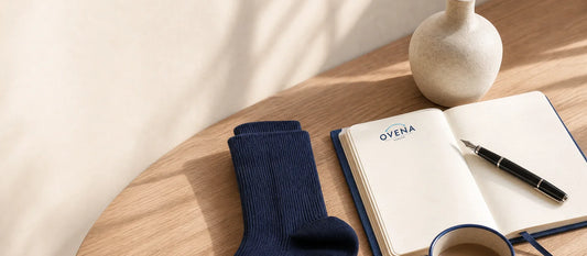 A single navy compression sock laid flat beside a notebook