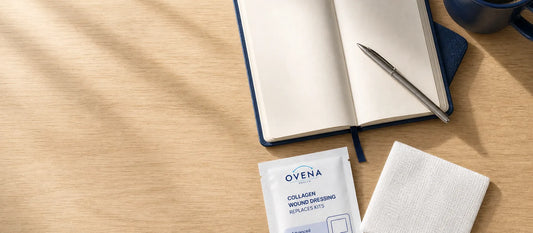 A collagen dressing packet and folded pad beside an open notebook