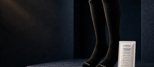 Black compression socks and cleanser on a stone pedestal